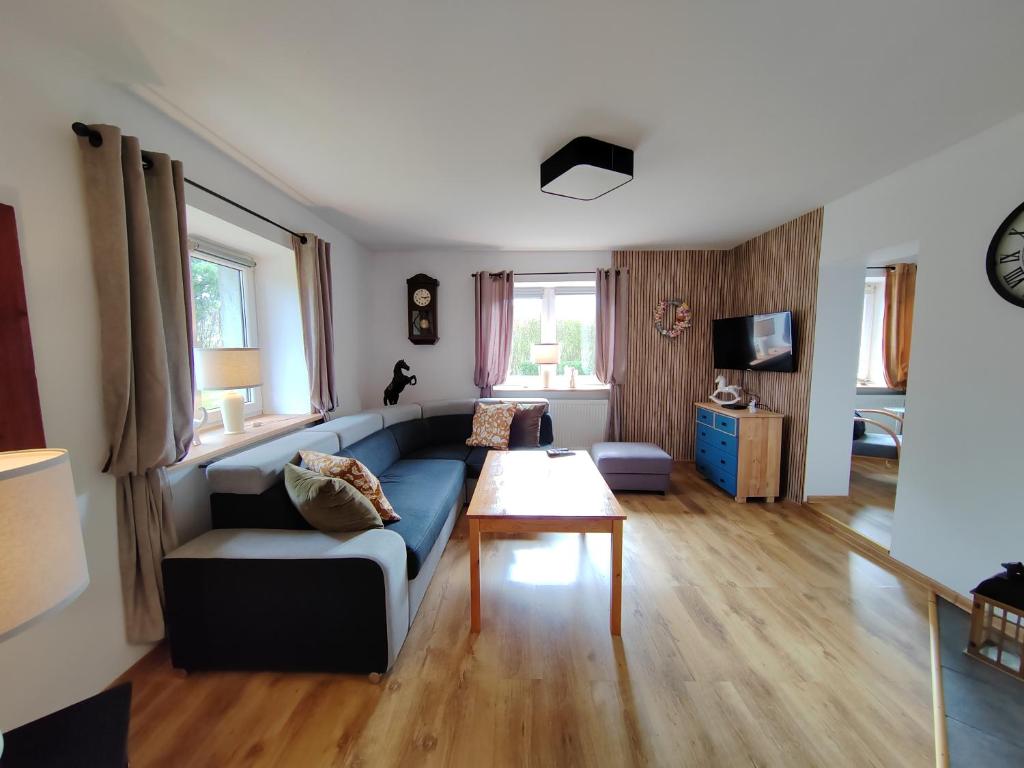 a living room with a blue couch and a table at DOM w JARNOŁTOWIE in Otmuchów