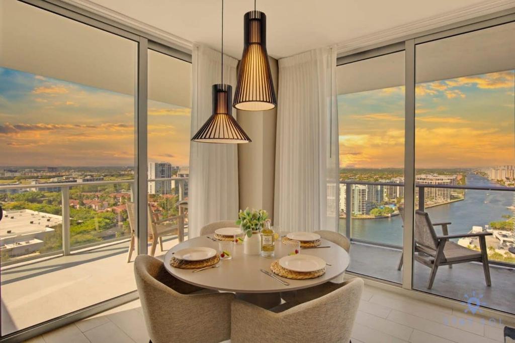 a dining room with a table and chairs and large windows at High Floor with Stunning Views, Amazing Pools in Hollywood
