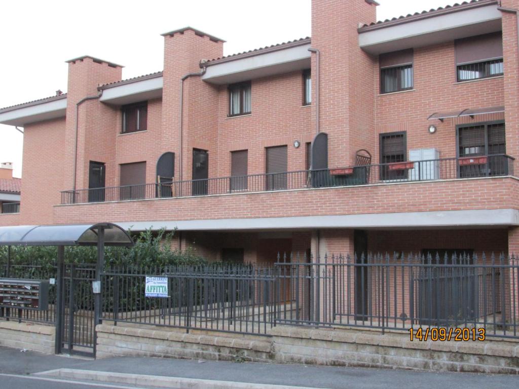 ein großes rotes Backsteingebäude mit einem Balkon in der Unterkunft casa fiano in Fiano Romano