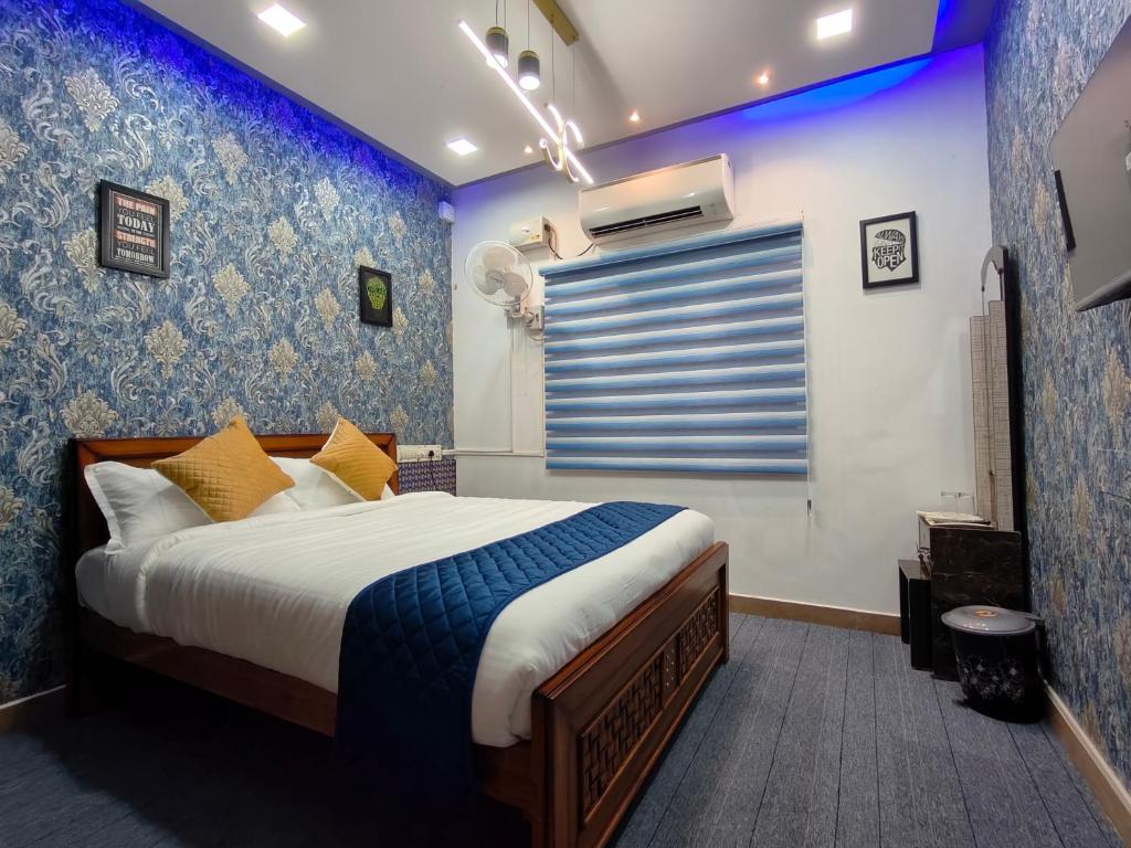 una camera con letto e parete blu di Sunshine Villa & Homestay a Tiruchchirāppalli