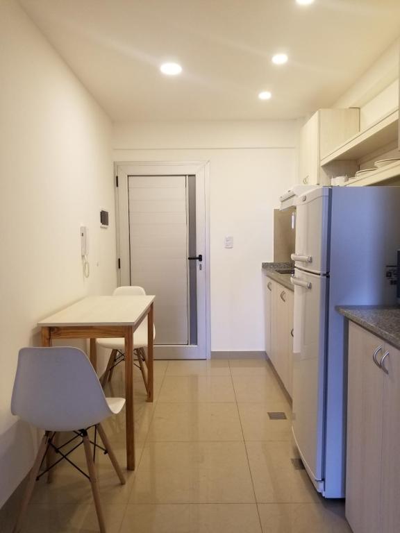 里奧哈的住宿－DELFINA suites 3A，厨房配有桌子和蓝色冰箱。