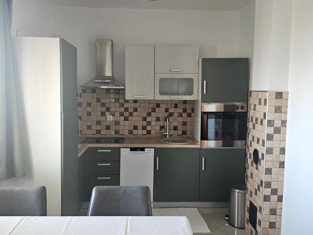 a kitchen with green cabinets and a sink at Apartments Marin in Senj