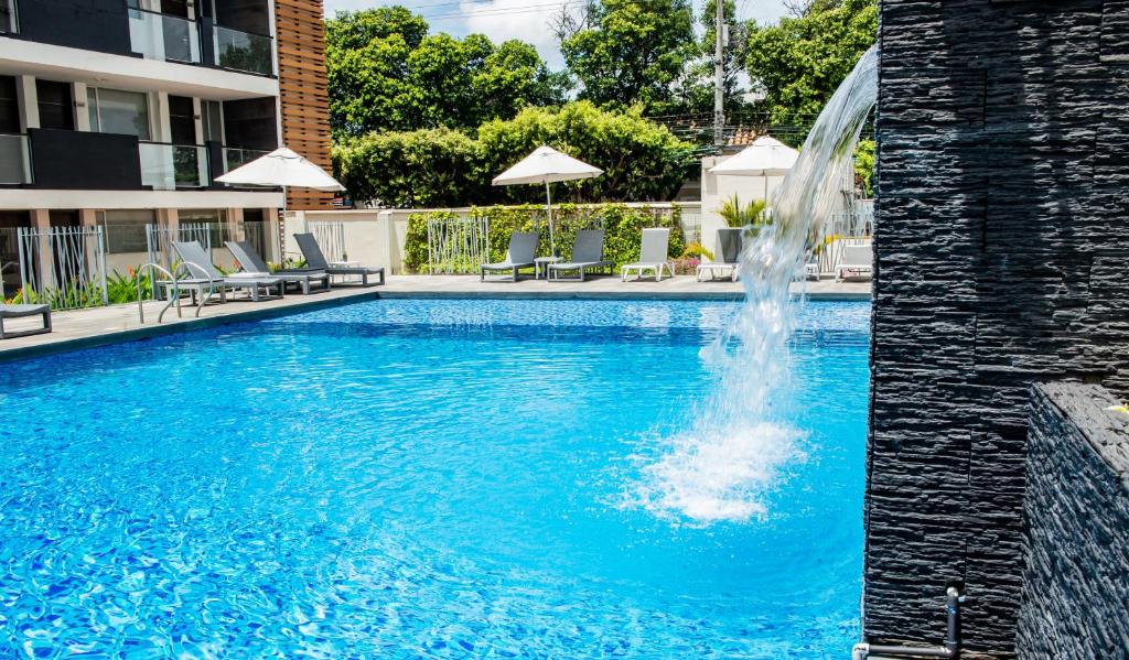 a swimming pool with a waterfall in a building at Hotel CasaBlanca Cucuta in Cúcuta