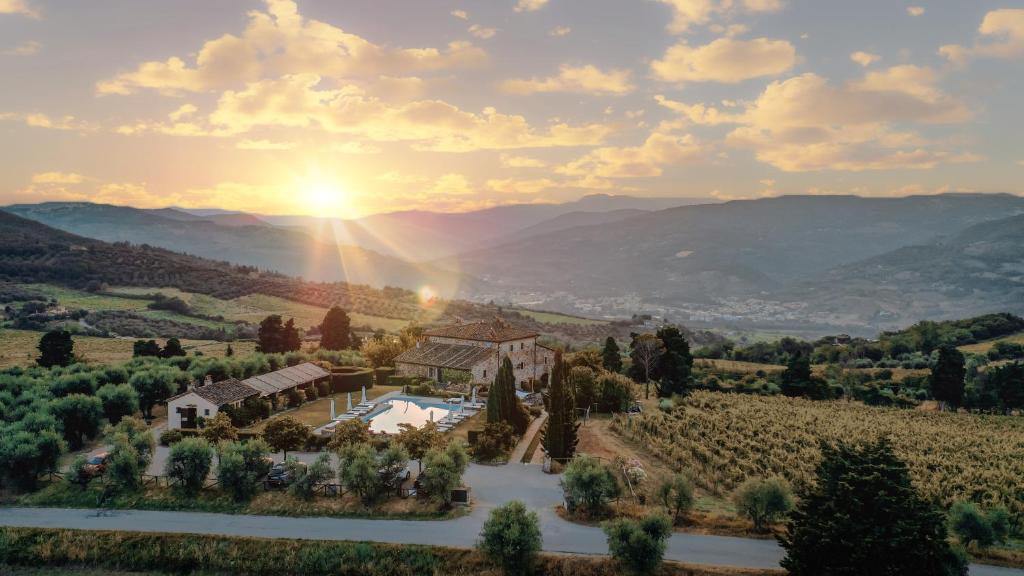 an aerial view of a villa in a vineyard with the sun setting at Agriturismo Fattoria Lavacchio in Pontassieve