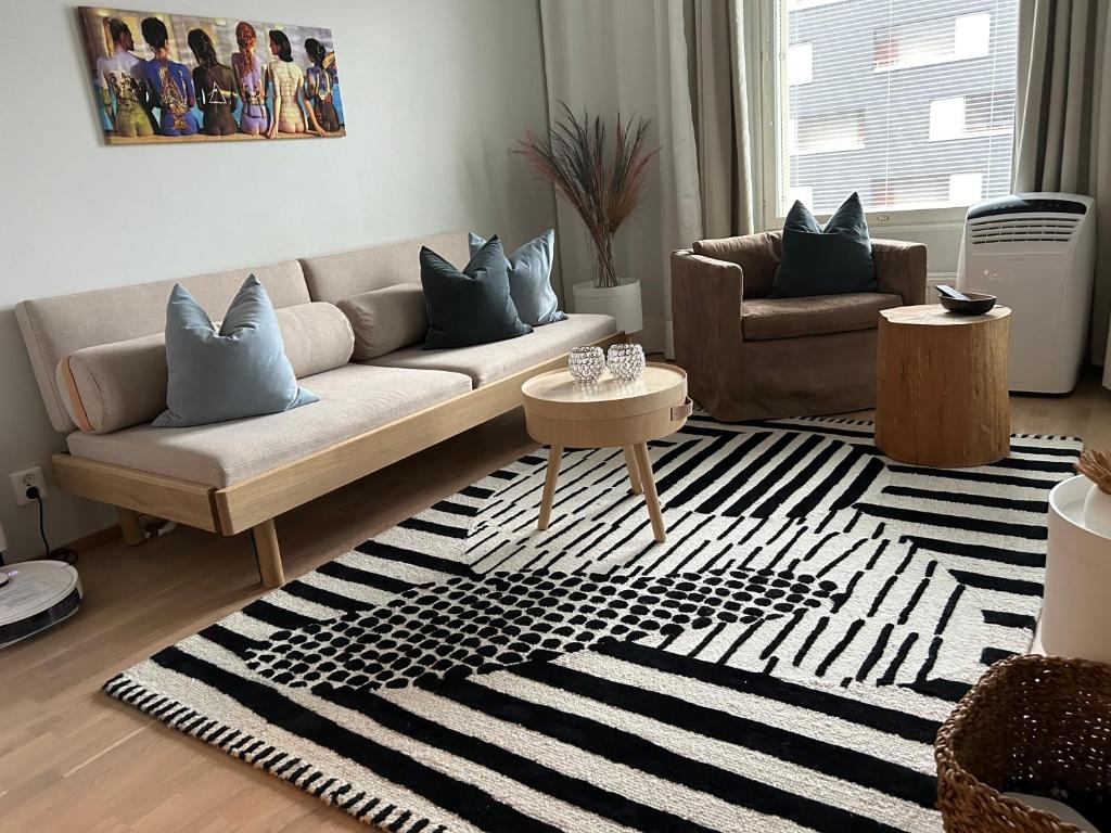 een woonkamer met een bank en een tapijt bij Beautiful apartment - own parking space included in Vantaa