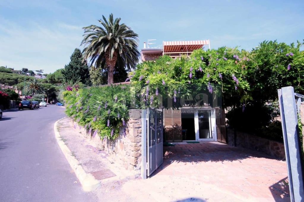 Un edificio con un cancello con dei fiori sopra di appartamento MONO GLICINE ristrutturato, veranda e clima a Castiglione della Pescaia