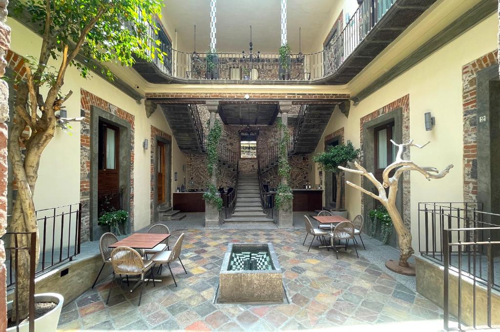 un patio con mesas, sillas y una fuente en Milo Collection Hotel en Puebla