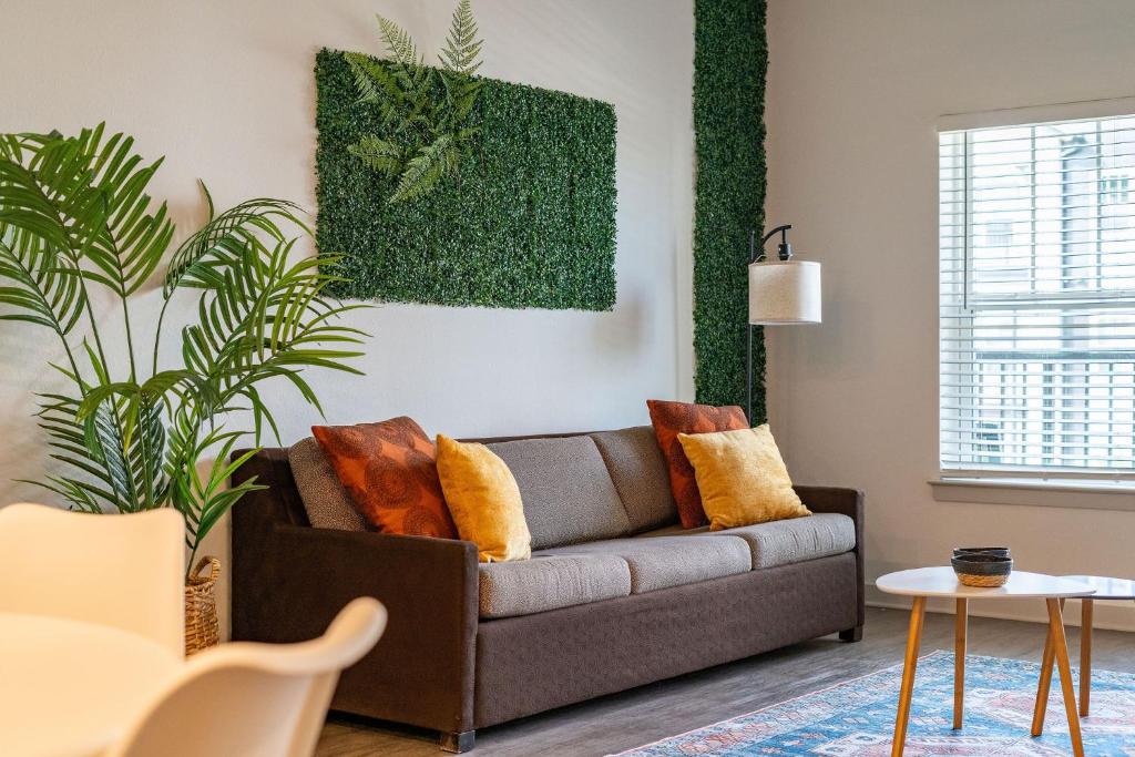 ein Wohnzimmer mit einem Sofa und einer Pflanze in der Unterkunft Lush Green Retreat 10 Min to Parks Pets Allowed in Orlando