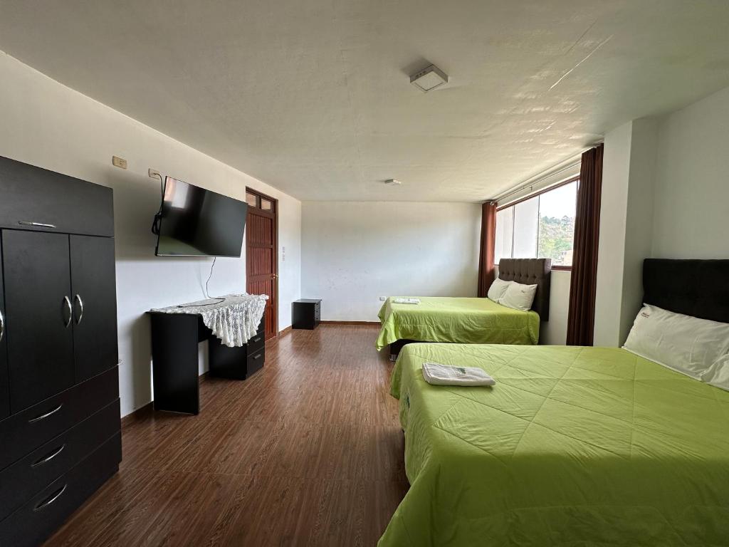 Habitación de hotel con 2 camas y TV de pantalla plana. en Hotel Ñuñurco Travellers, en Chachapoyas