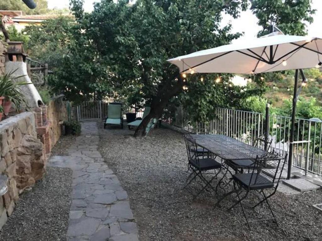 a table and chairs with an umbrella in a yard at Casa Francesca in Scarlino