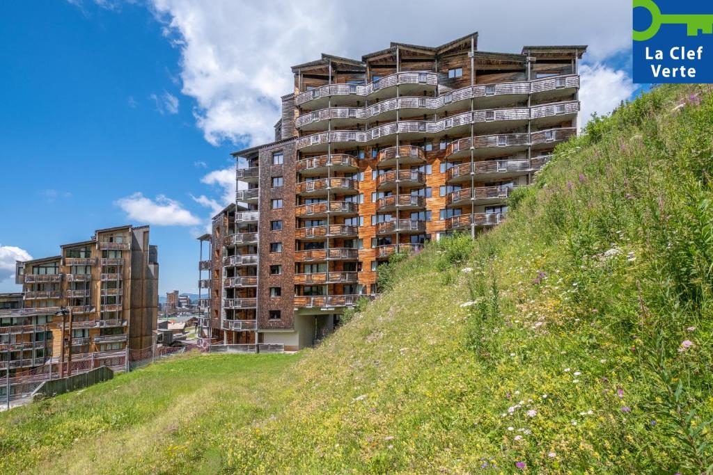 un grand bâtiment au sommet d'une colline herbeuse dans l'établissement Résidence Pierre & Vacances Electra, à Avoriaz