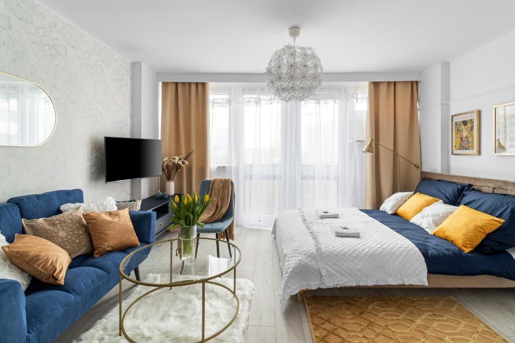 a living room with a blue couch and a table at Beautiful freshly renovated studio in Warsaw centre, full comfort metro Smart TV parking in Warsaw