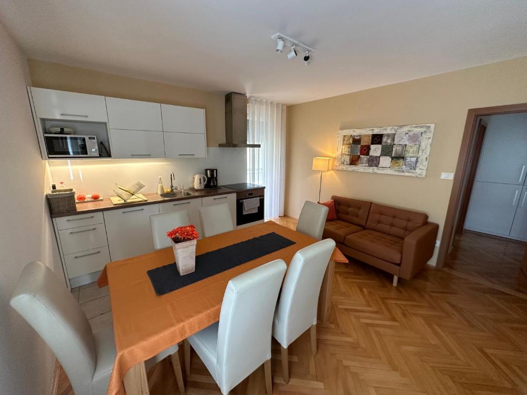 eine Küche und ein Esszimmer mit einem Tisch und einem Sofa in der Unterkunft Apartment with balcony Hiša Brdo 48 in Bovec