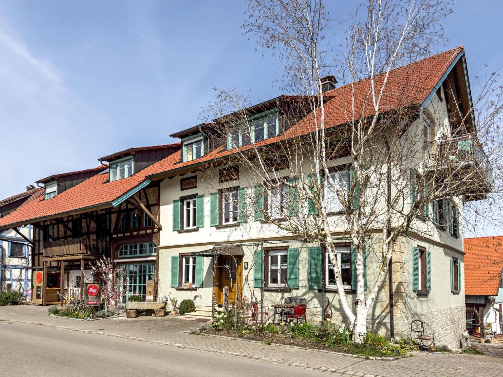 ein großes Gebäude mit rotem Dach auf einer Straße in der Unterkunft Obst- Ferienhof Ragg in Immenstaad am Bodensee