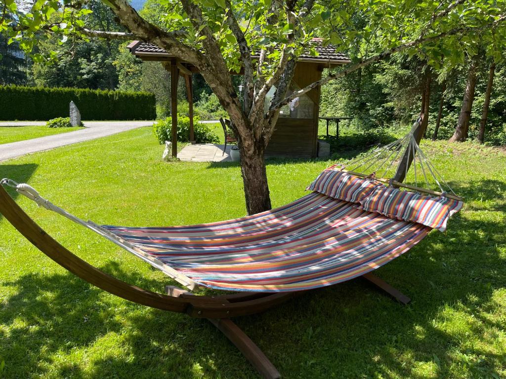 a hammock sitting in the grass next to a tree at Haus Landruhe in Greifenburg