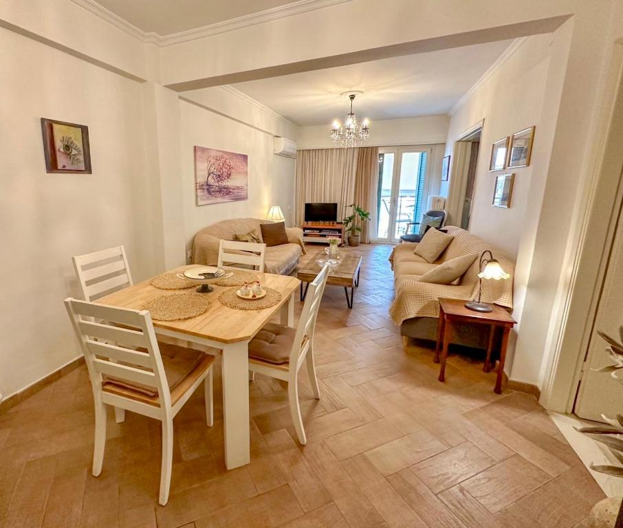 uma sala de jantar e sala de estar com mesa e cadeiras em Elli & Klairi Apartment em Ágios Rókkos