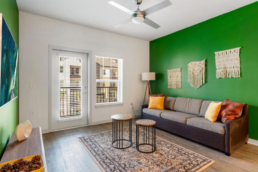 a living room with a couch and a green wall at Cozy 2Bed Boho Hideaway 10 Min to Parks Allows Pet in Orlando