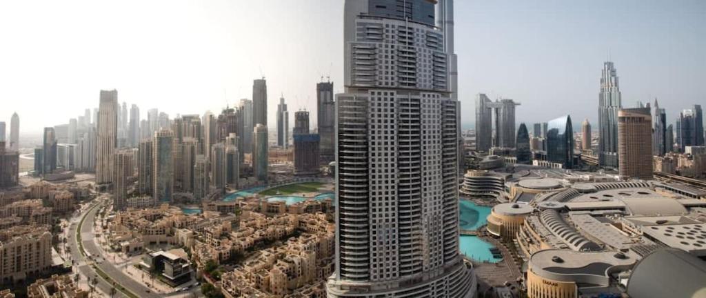 a large city with a tall building in the foreground at Frank Porter - Boulevard Point in Dubai