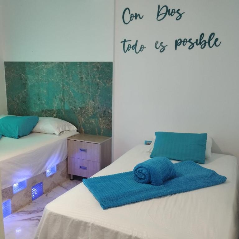 a room with two beds and a sign that says our best trip is possible at HOTEL DE LOS COLORES in El Queremal