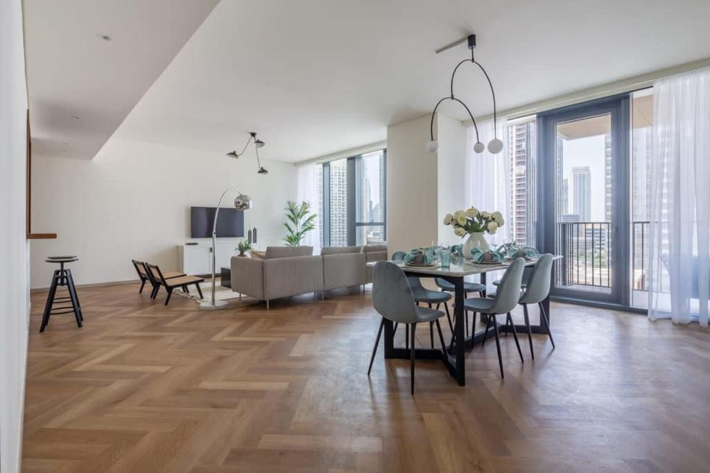 a dining room and living room with a table and chairs at Frank Porter - BLVD Heights T1 in Dubai