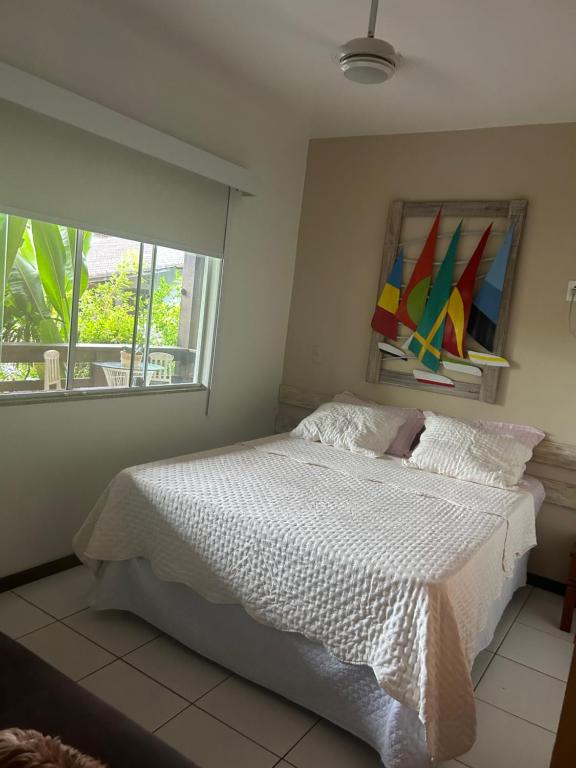 a bedroom with a white bed and a window at Passeios jet home in Angra dos Reis