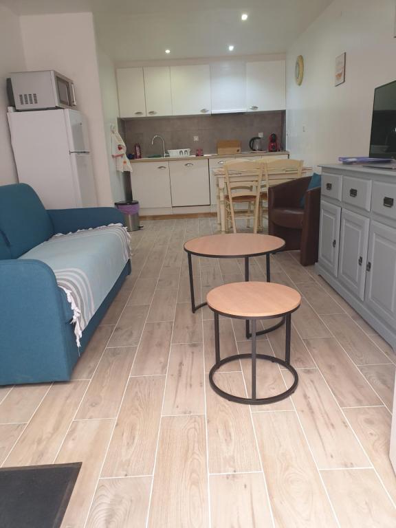 ein Wohnzimmer mit einem Sofa und einem Tisch sowie eine Küche in der Unterkunft Saint Laurent de la Salanque Charmant T2 classé 3 étoiles in Saint-Laurent-de-la-Salanque