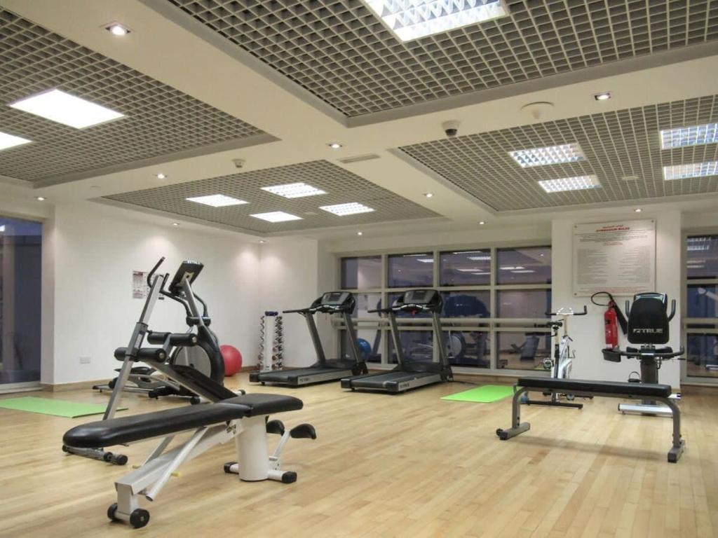a gym with several treadmills and elliptical machines at Frank Porter - Goldcrest Executive in Dubai