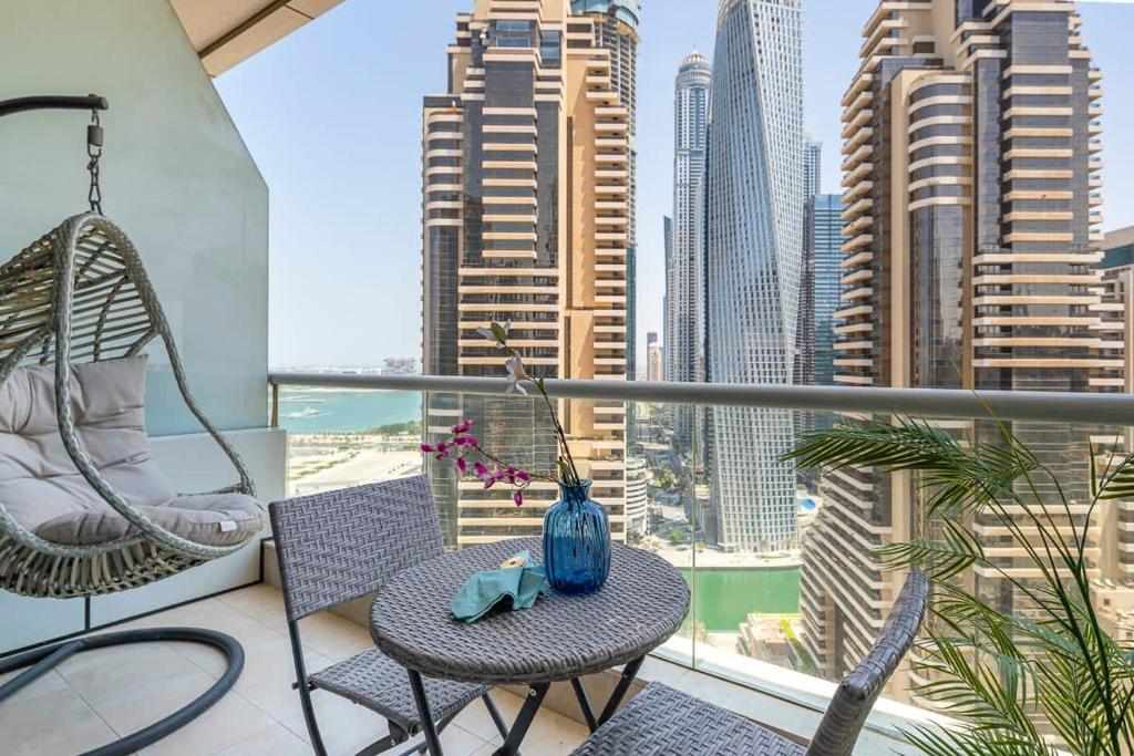 a balcony with a table and chairs and a view of a city at Frank Porter - Botanica Tower in Dubai
