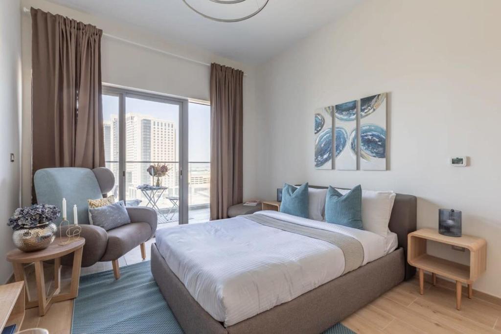 a hotel room with a large bed and a balcony at Frank Porter - Aura by Azizi in Dubai