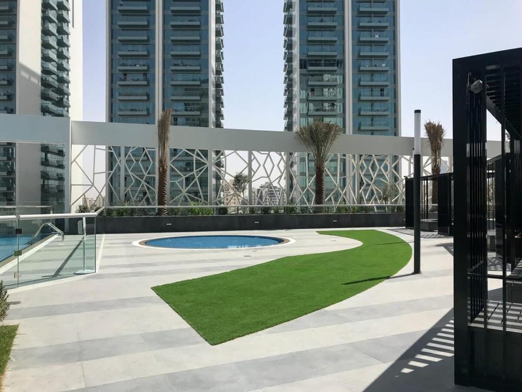 a courtyard with a swimming pool and tall buildings at Frank Porter - Bella Rose in Dubai