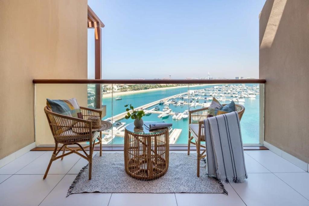 a balcony with chairs and a view of a harbor at Frank Porter - Palm Views in Dubai