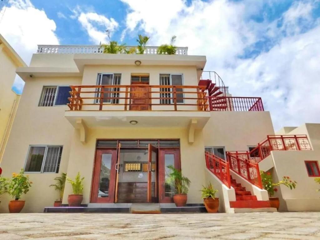 a house with red stairs in front of it at Tranquil Pendo villas in Diani Beach