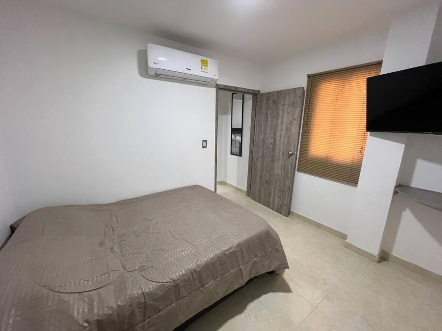 a bedroom with a bed and a flat screen tv at Apto 301 cerca a C.C. unicentro in Cúcuta