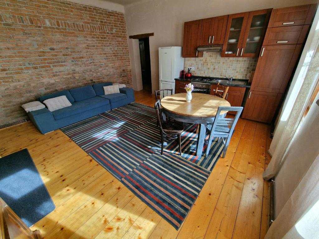 sala de estar con mesa y sofá azul en World Studio Family Apartment, en Sibiu