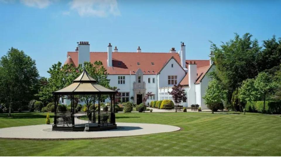 uma grande casa branca com um gazebo no quintal em Lochgreen House Hotel & Spa em Loans