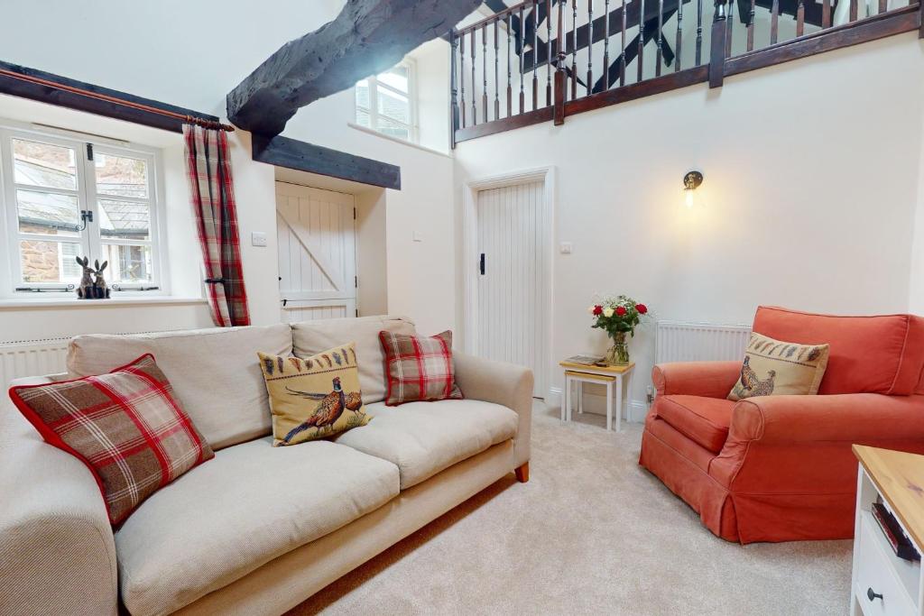 a living room with a couch and a chair at The Barn Timberscombe in Timberscombe