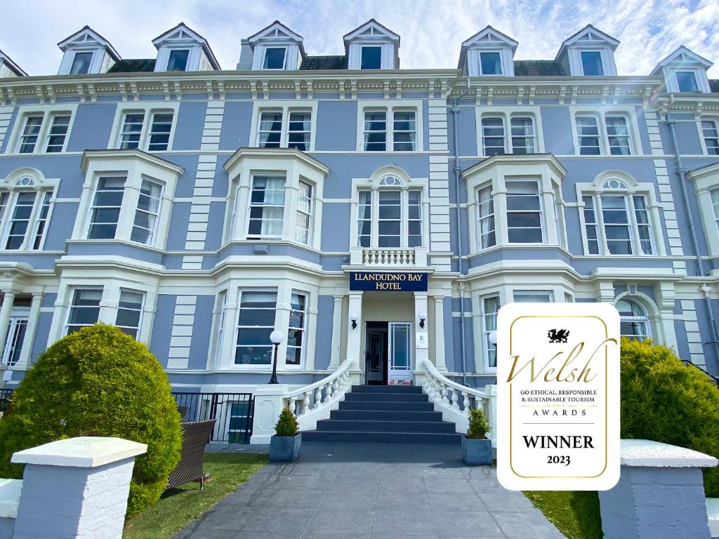 un edificio blu con un cartello davanti di Llandudno Bay Hotel a Llandudno