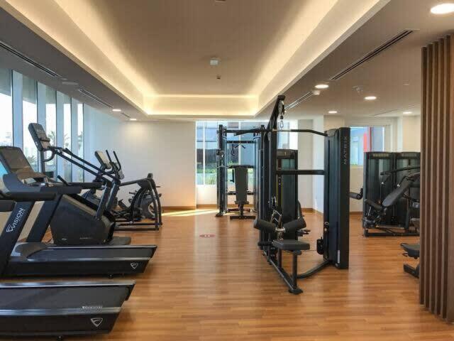 a gym with several tread machines in a room at Frank Porter - Bloom Towers in Dubai
