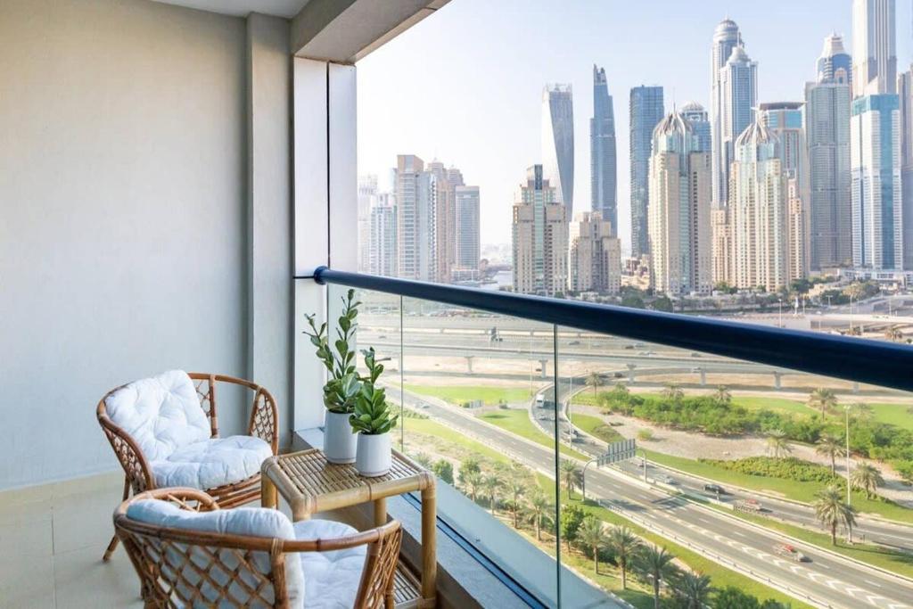 a balcony with two chairs and a view of the city at Frank Porter - X1 Tower in Dubai