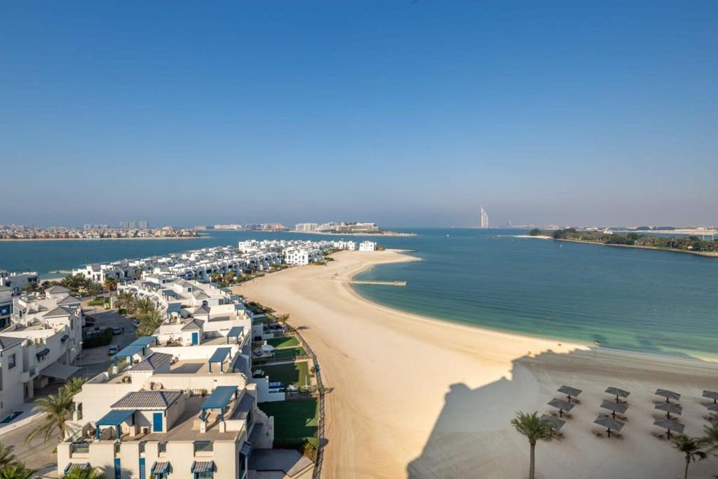 ドバイにあるFrank Porter - Al Khudrawiの建物と海を望むビーチの景色を望めます。