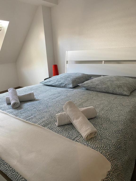 Una cama con dos toallas enrolladas. en Mulhouse hyper centre appartement 4 chambres, en Mulhouse
