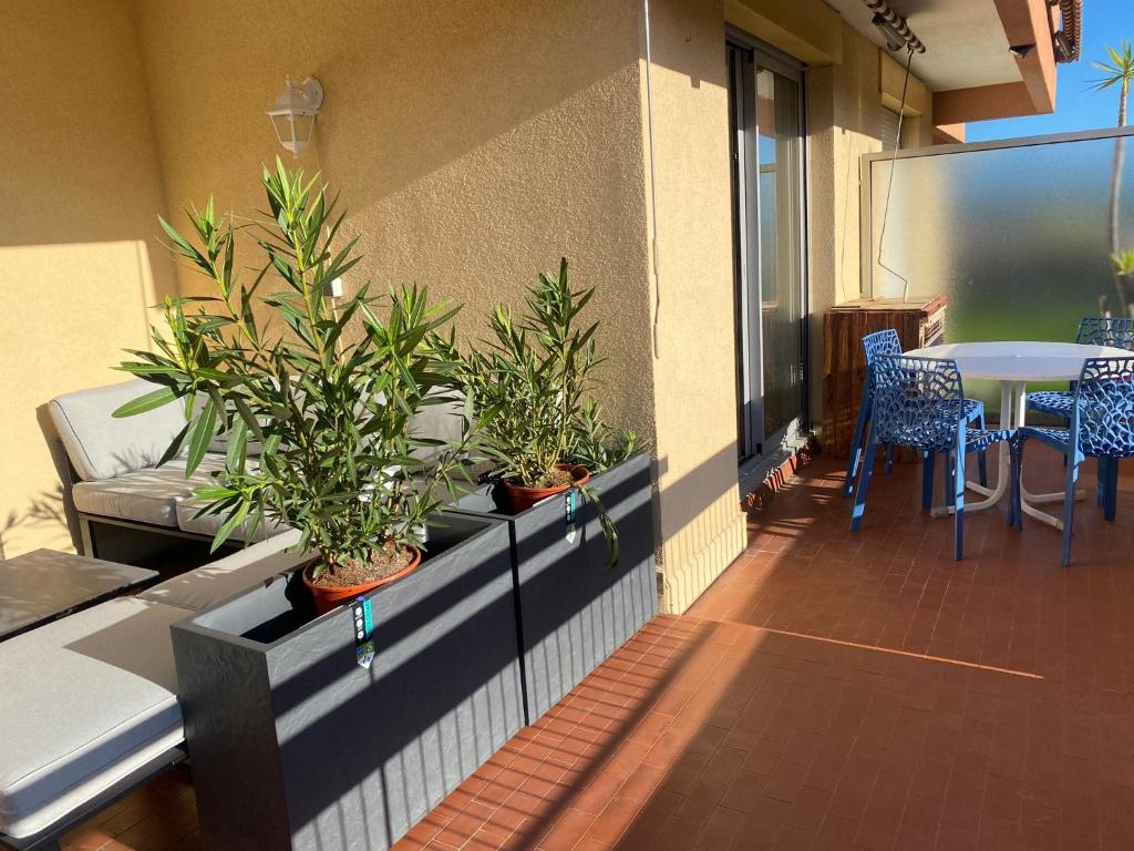- un balcon avec des plantes en pot sur le côté d'un bâtiment dans l'établissement Soleil et Mer, à Saint-Raphaël