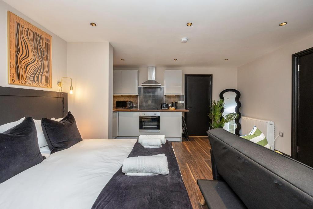 sala de estar con cama grande y cocina en Charming Brighton Studio Flat, en Brighton & Hove