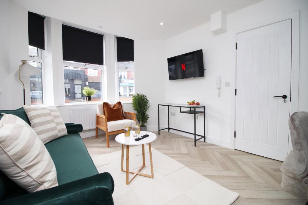 - un salon avec un canapé vert et une table dans l'établissement Centrally Located 2 Bedroom, à Cardiff