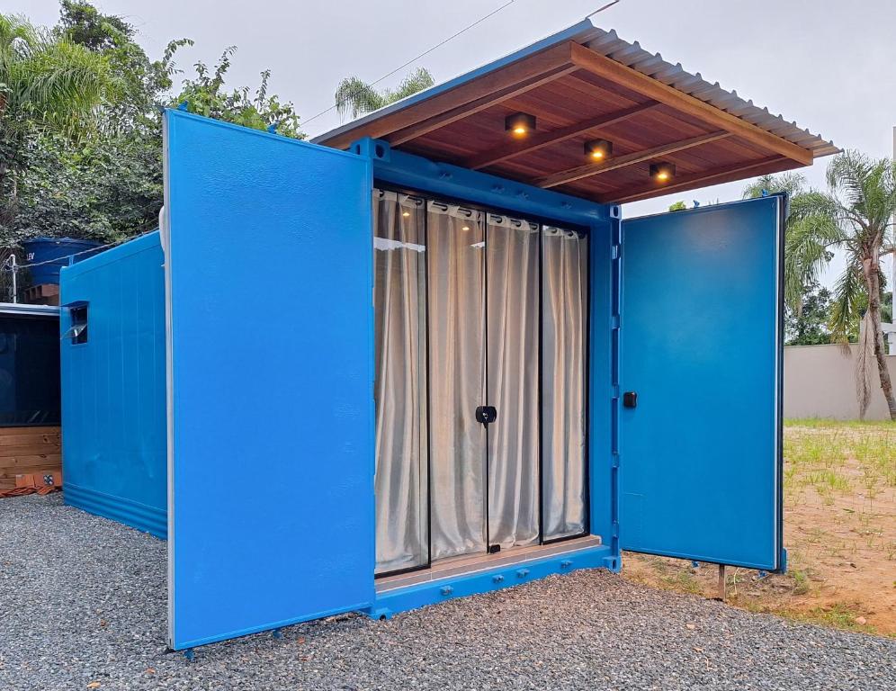 a blue container home with a large door at Casa Container Azul Mariscal in Bombinhas