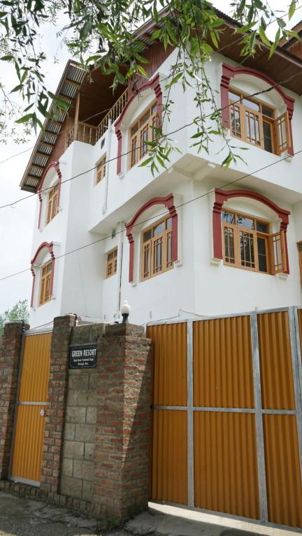 una casa con puertas naranjas y un garaje en Green Resort, en Rājbāgh