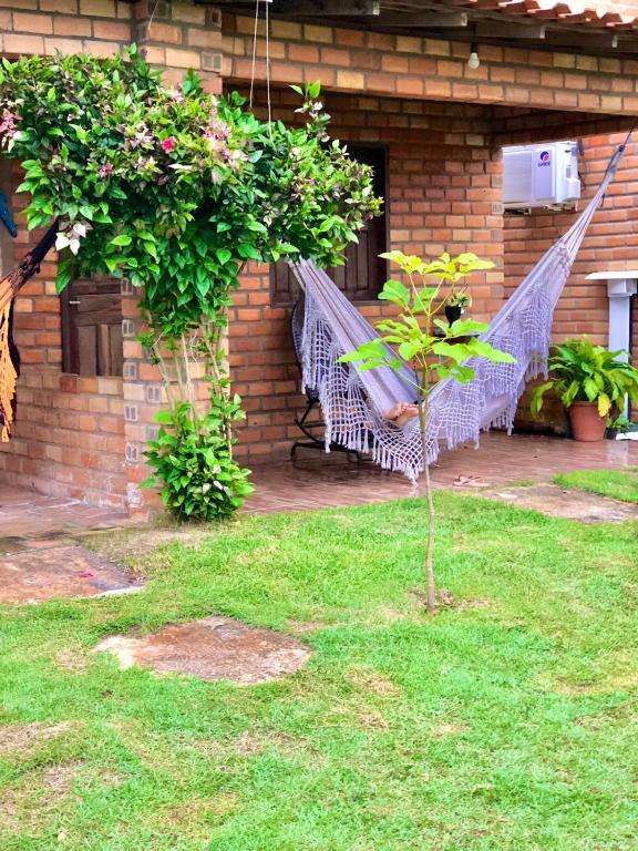 a hammock in a yard next to a house at Pousada Da Bell in Barreirinhas