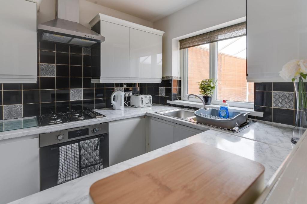 曼徹斯特的住宿－Remarkable 3-Bed House in Middleton Manchester，厨房配有白色家电和木制台面