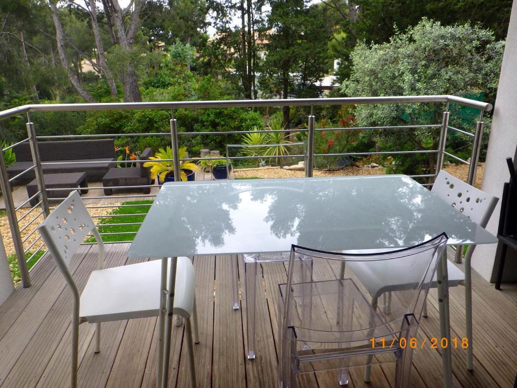 une table en verre et deux chaises sur une terrasse dans l'établissement 4 étoiles à 5mn à pied des plages, à Bandol