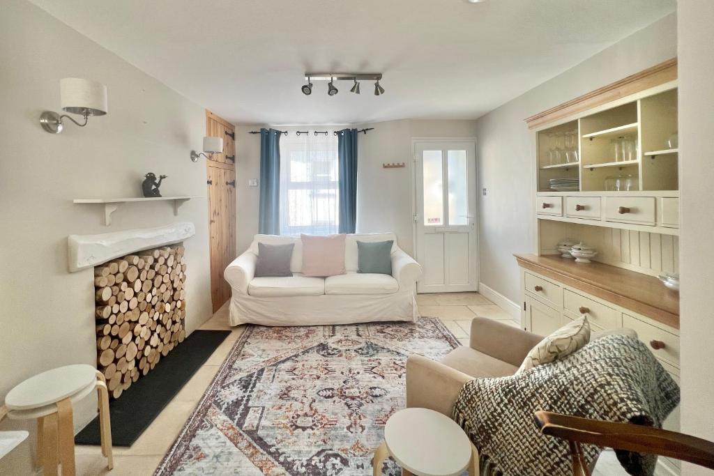 ein Wohnzimmer mit 2 Sofas und einem Kamin in der Unterkunft Farthing Cottage…cute ‘n’ cosy! in Kingsbridge